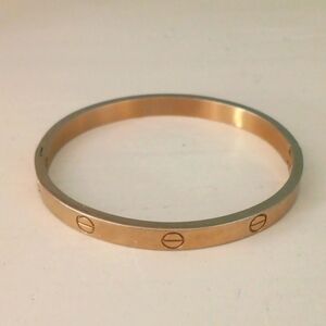 % Oval Gold Tone Bangle Bracelet with Screw Motif